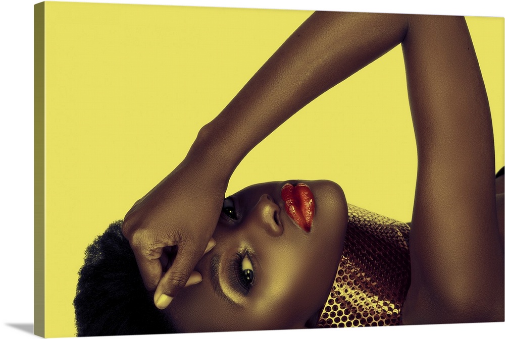 Beautiful South African woman with bronze necklace and natural make-up on yellow background.