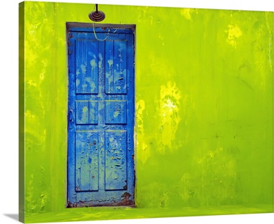 Blue Door In A Shabby Green Wall