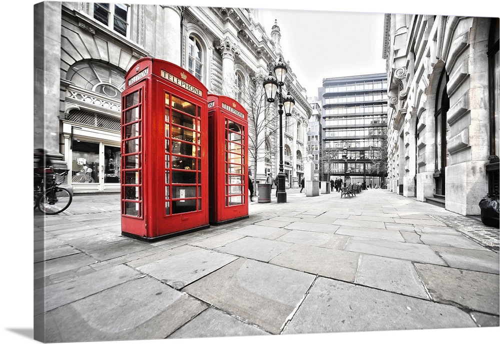 Two red phone booths on the street.