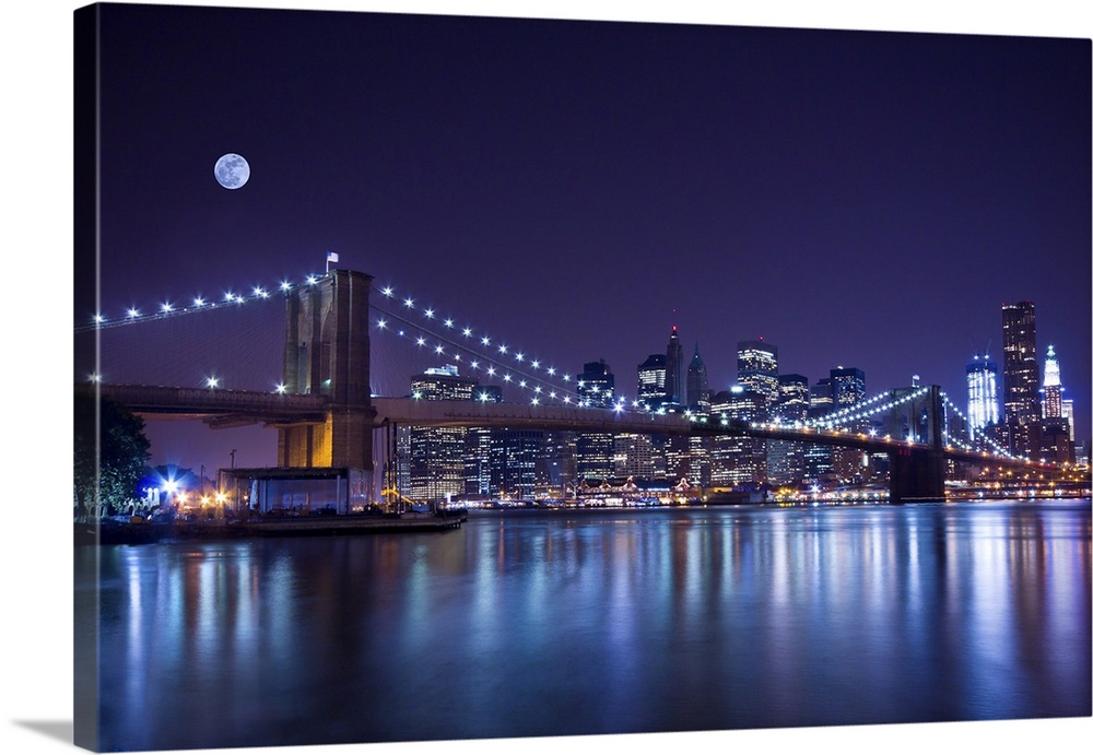 New York City's Brooklyn Bridge at night under a full moon.