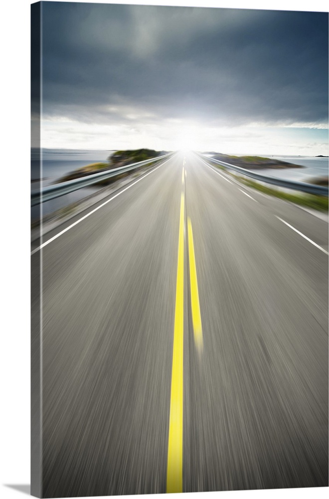 Scenic view of coastal highway or road receding on coastline with slow motion blur and sunny background.