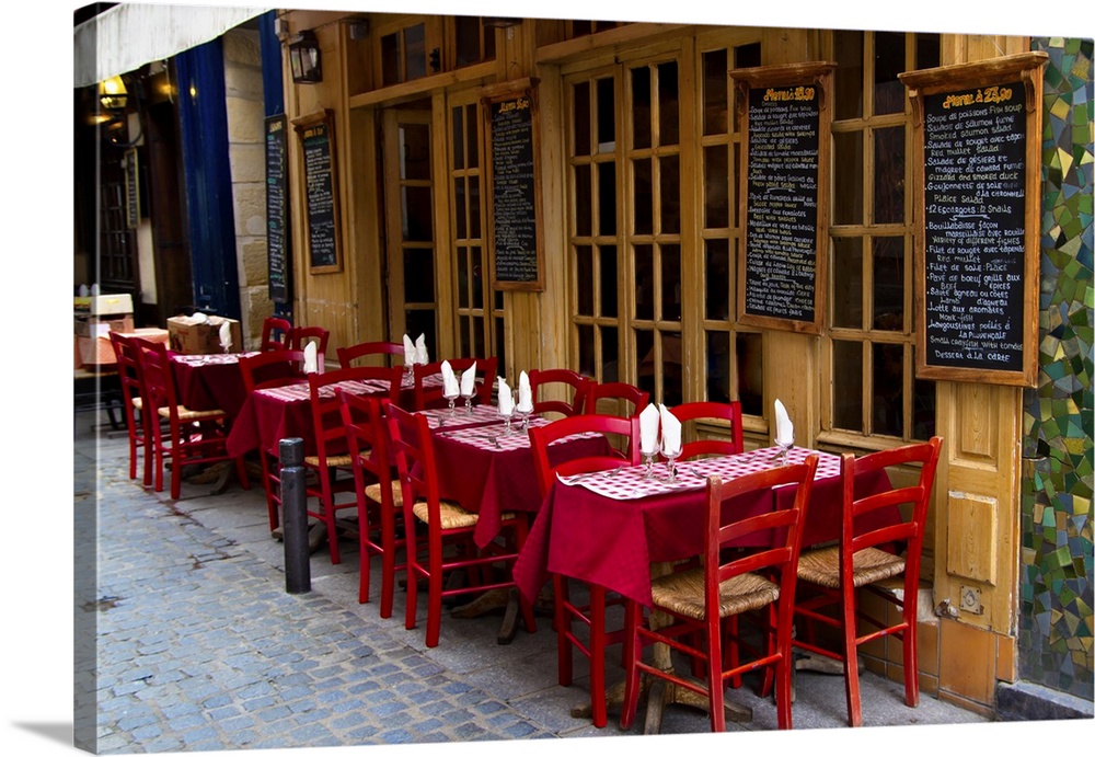 French restaurant with tables and chairs on the street in Paris, France.