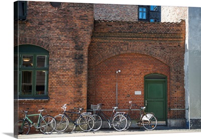 Parked Bicycles Near Brick Wall Of Building Of Copenhagen, Denmark