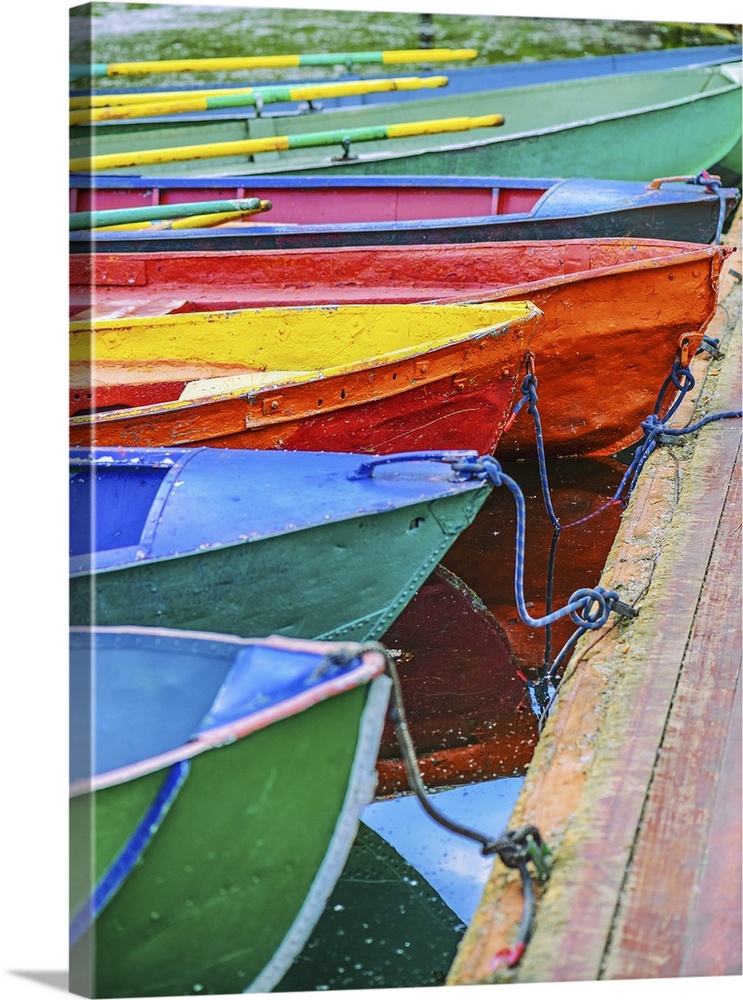 Colorful small boats parked to wooden pier.