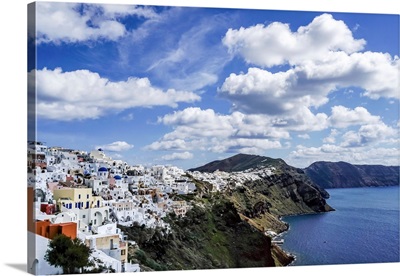 White Houses Near Tranquil Sea Against Blue Sky With Clouds In Greece
