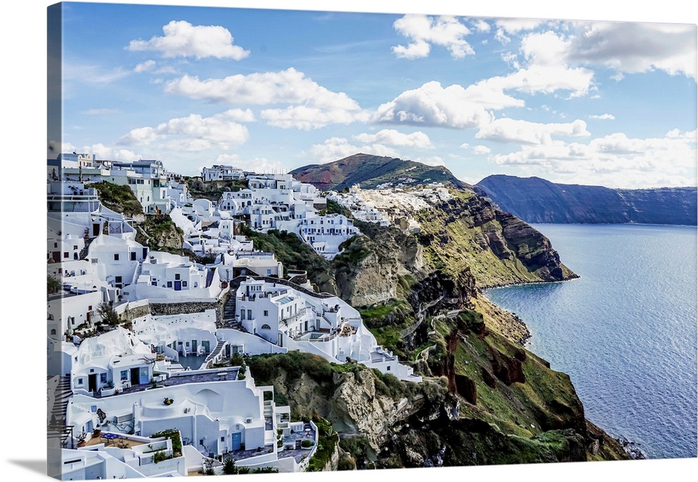 White houses near tranquil sea against sky with clouds in greece.
