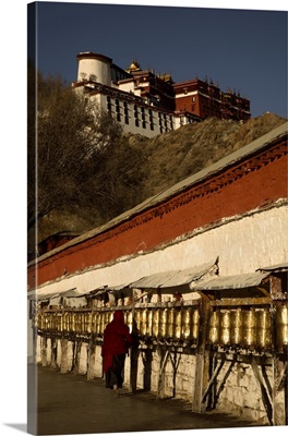 China, Tibet, Lhasa, Pilgrim woman spinning prayer wheels outside the Potala