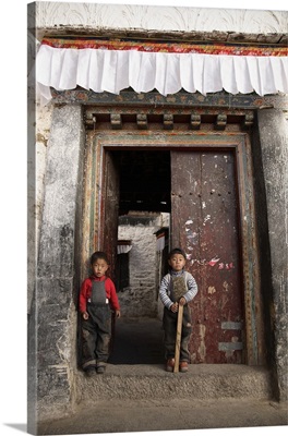 China, Tibet, Lhasa, Tibetan boys guarding the doorway to their traditional home