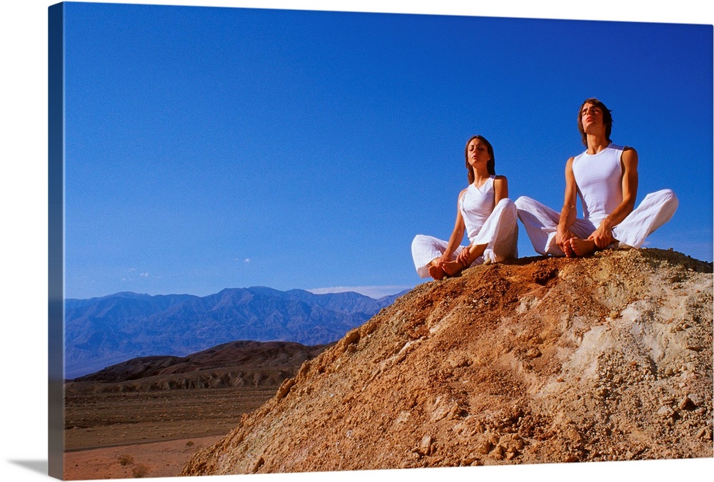 Couple sitting on rock, meditating