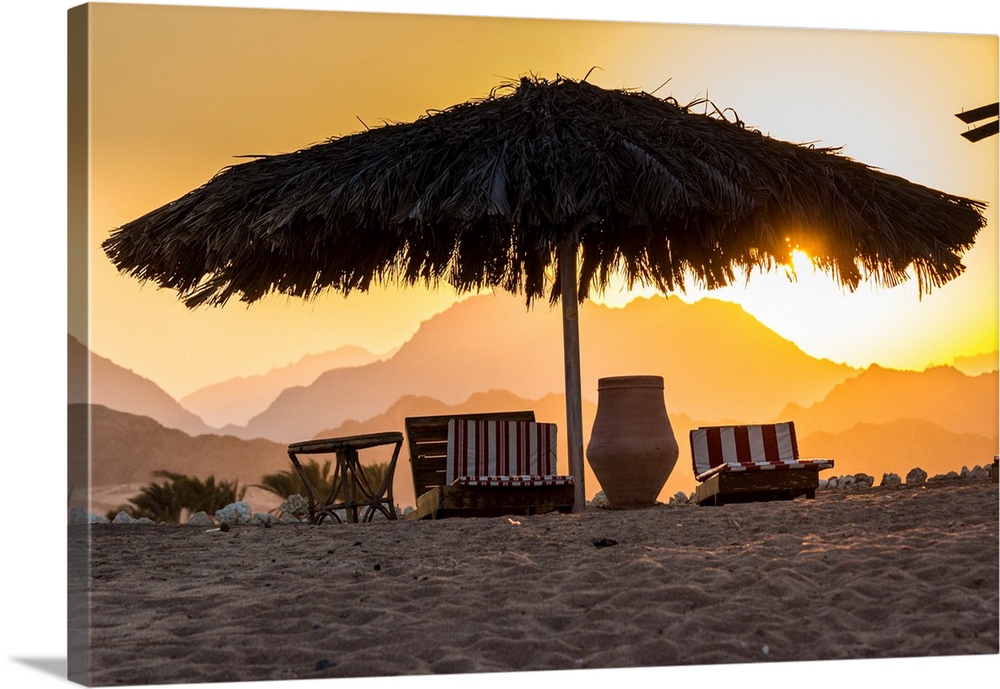 Egypt, Sinai, Sharm el Sheikh, Red sea, Nabq Bay, beach beds at sunset with Sinais mountains behind.