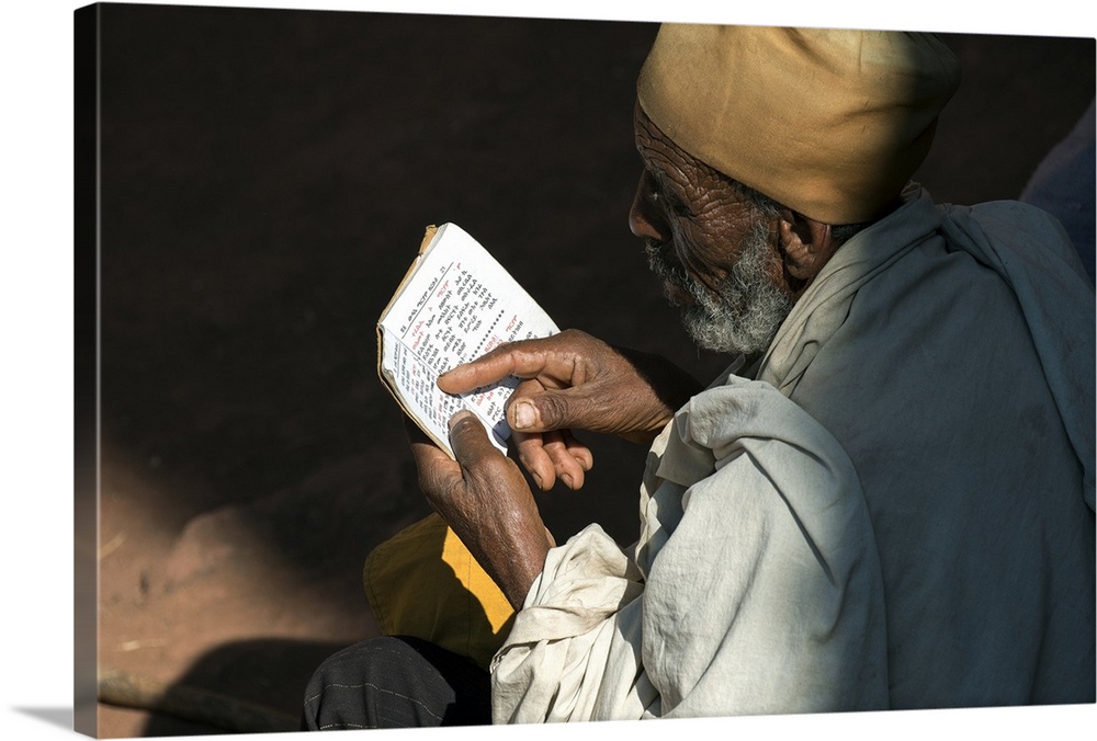 Ethiopia, Amhara, Lalibela, Monk reading Bible at Biete Abba Libanos.
