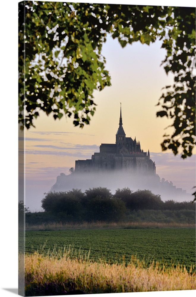 France, Normandy, Mont Saint-Michel, Atlantic ocean, Basse-Normandie, Le Mont-Saint-Michel at dawn appears in the fog.