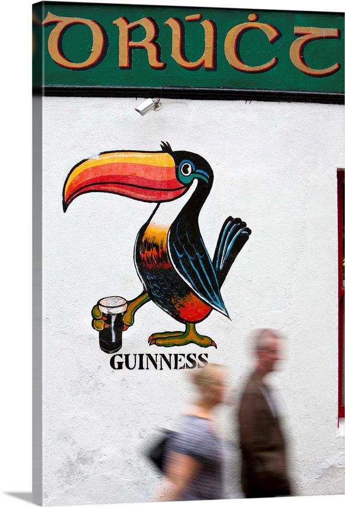 Ireland, Galway, People walk by a traditional Pub with Gaelic sign writing