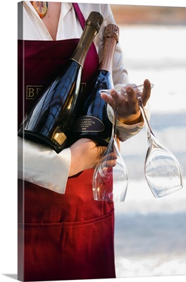 Italy, Lombardy, Waitress bringing bottles of Bellavista sparkling wine