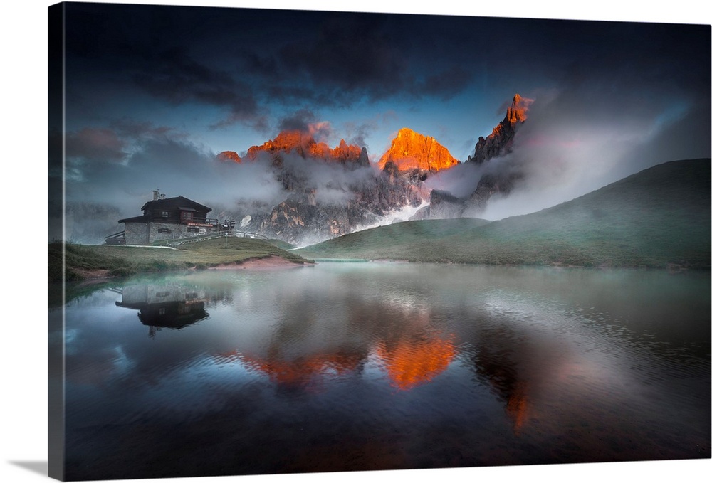 Italy, Trentino, Pale di San Martino, reflecting on an alpine lake on a cloudy sunset.