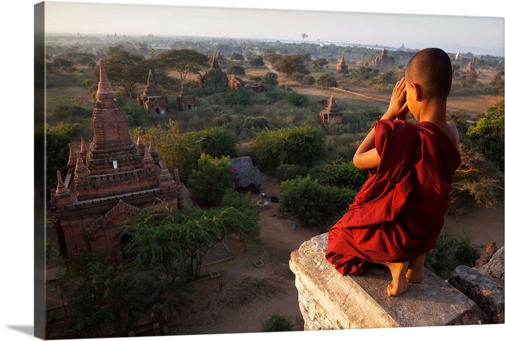 Myanmar, Bagan, A novice Buddhist monk prays on a temple at sunrise