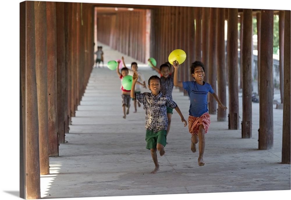 Myanmar, Mandalay, Bagan, Local children running along a passage with balloons.