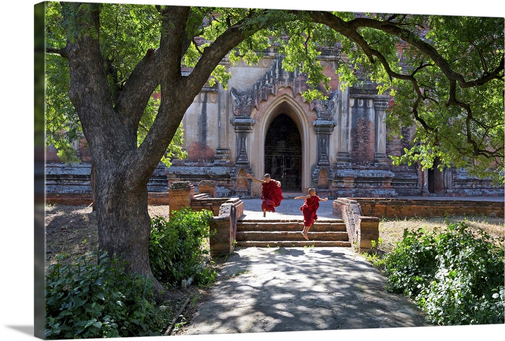 Myanmar, Mandalay, Bagan, Novice monks jumping down the steps of the Ananda temple.