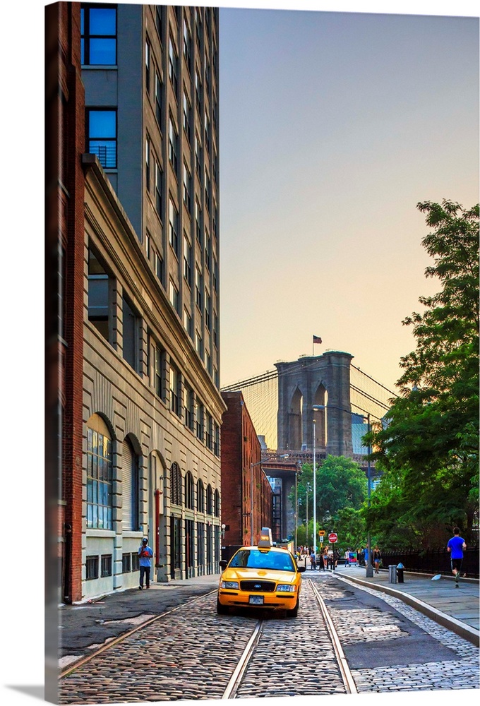 USA, New York City, Manhattan, Lower Manhattan, Brooklyn Bridge, Taxi driving along a cobblestone road.