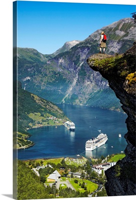 Norway, Geiranger, Hiker at Flydalsjuvet Rock and cruise ships in Geirangerfjord