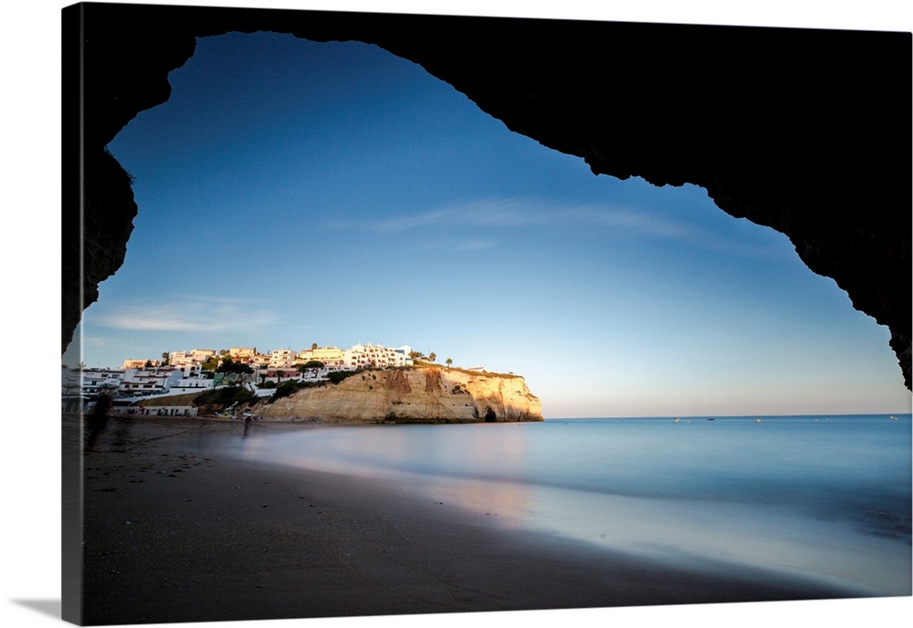 Portugal, Faro, Carvoeiro, View from a sea cave of the fishing village of Carvoeiro perched on a reef at sunset.