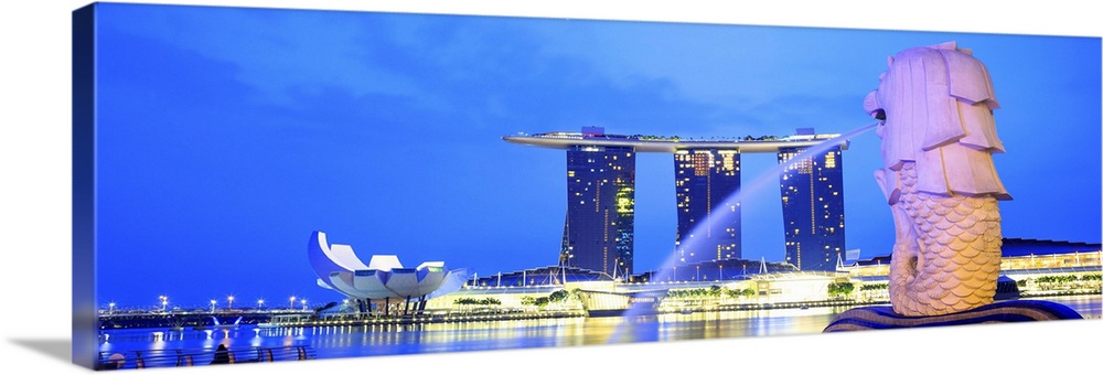 Singapore, Singapore City, Merlion fountain at night with the Marina Bay Sands in the background.
