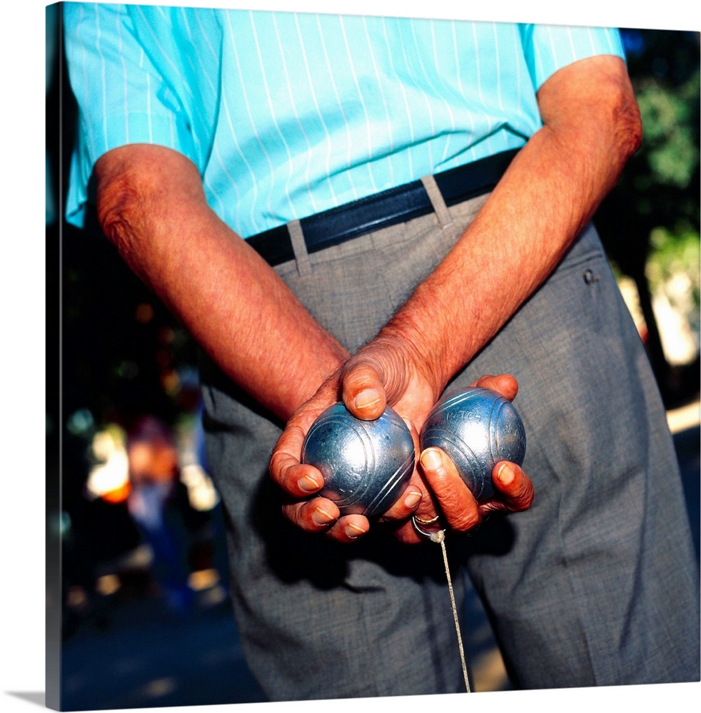 Spain, Barcelona, Man holding two boules behind his back
