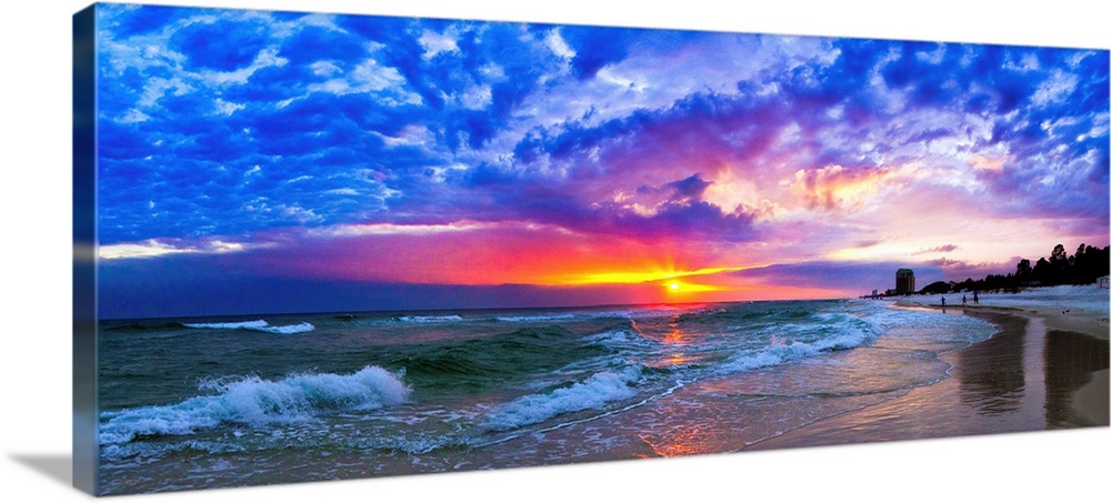 An amazing beach sunset panorama with waves and blue clouds.