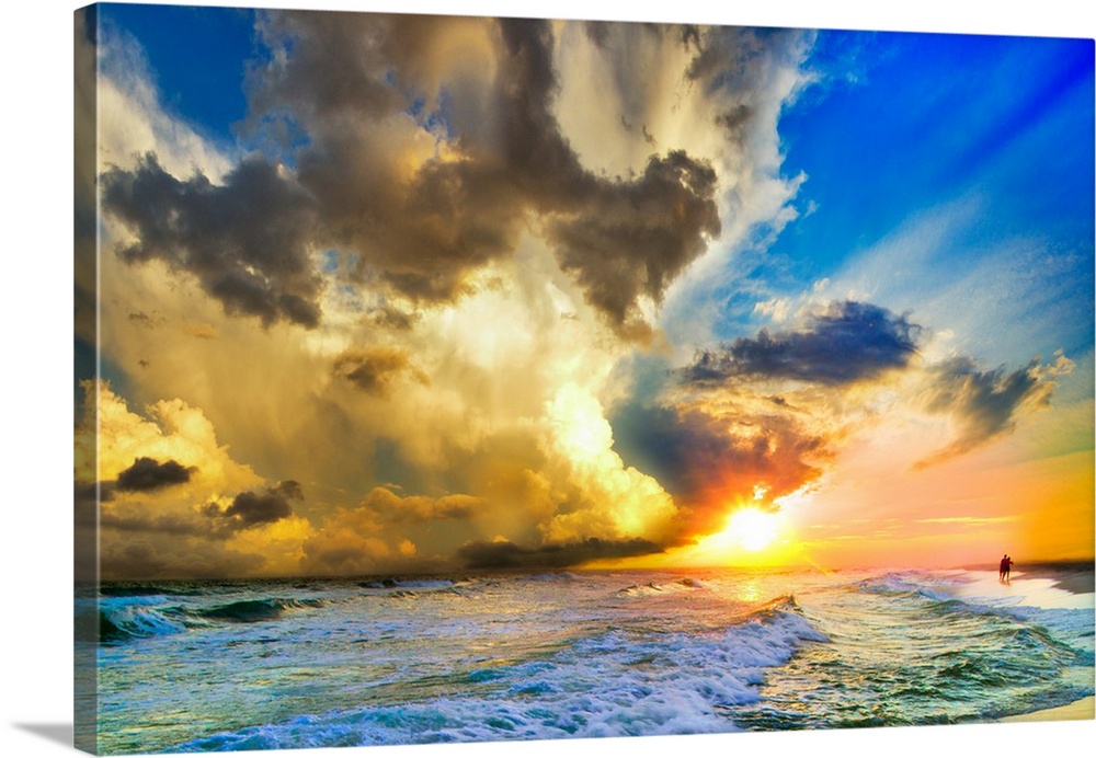 Tall clouds before a blue sky and a sunset over a beautiful beach landscape.
