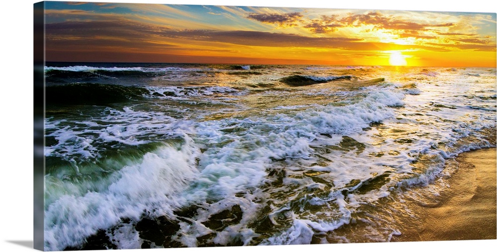 A beautiful ocean sunrise over breaking ocean waves. An art print with waves on the beach with a golden beach sunset with ...
