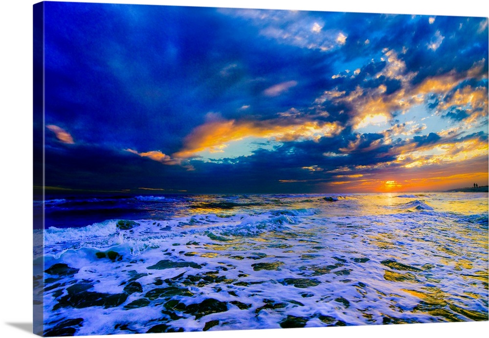A beautiful blue beach sunset in this landscape seascape photo. An art print featuring a blue sea waves in a Dark and Stor...