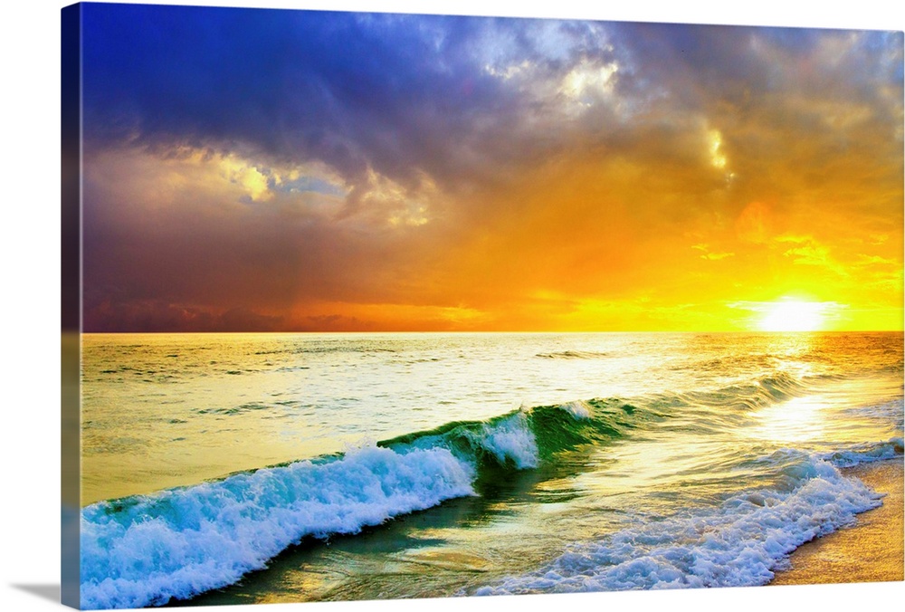 Waves breaking from an emerald sea beneath an orange and blue ocean sunset with green sea surf.