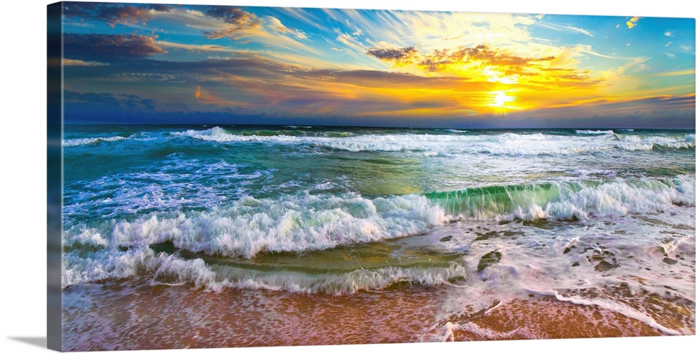 This panoramic beach sunset features breaking waves on a beautiful sea shore. A wave crashes on the shore before an orange...