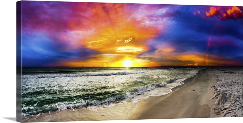 A dark rainbow sunset with a beautiful blue, purple and red sky. This is a large beach panorama.