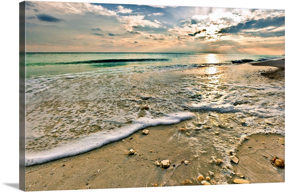 A sandy shell covered beach and emerald green waves under a bright sunset. A very tranquil and relaxing Florida vacation s...