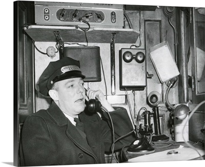 Conductor uses an on board telephone to communicate with other parts of the train