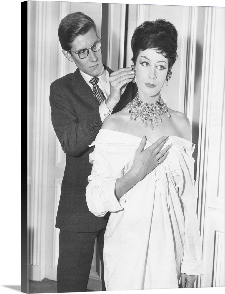 French fashion designer Yves Saint Laurent putting earing on model. Jan. 18, 1962.