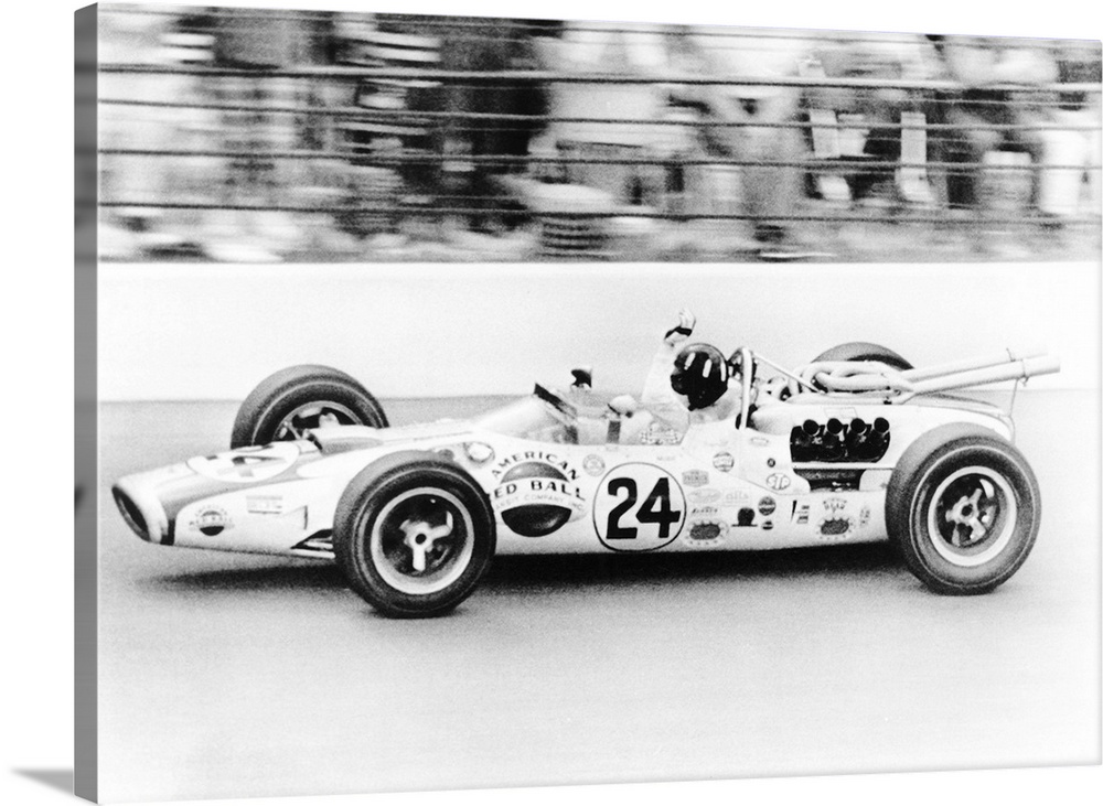 Graham Hill, waves as his car streaks toward the finish line to win the Indianapolis 500. May 30, 1966. The Golden Anniver...