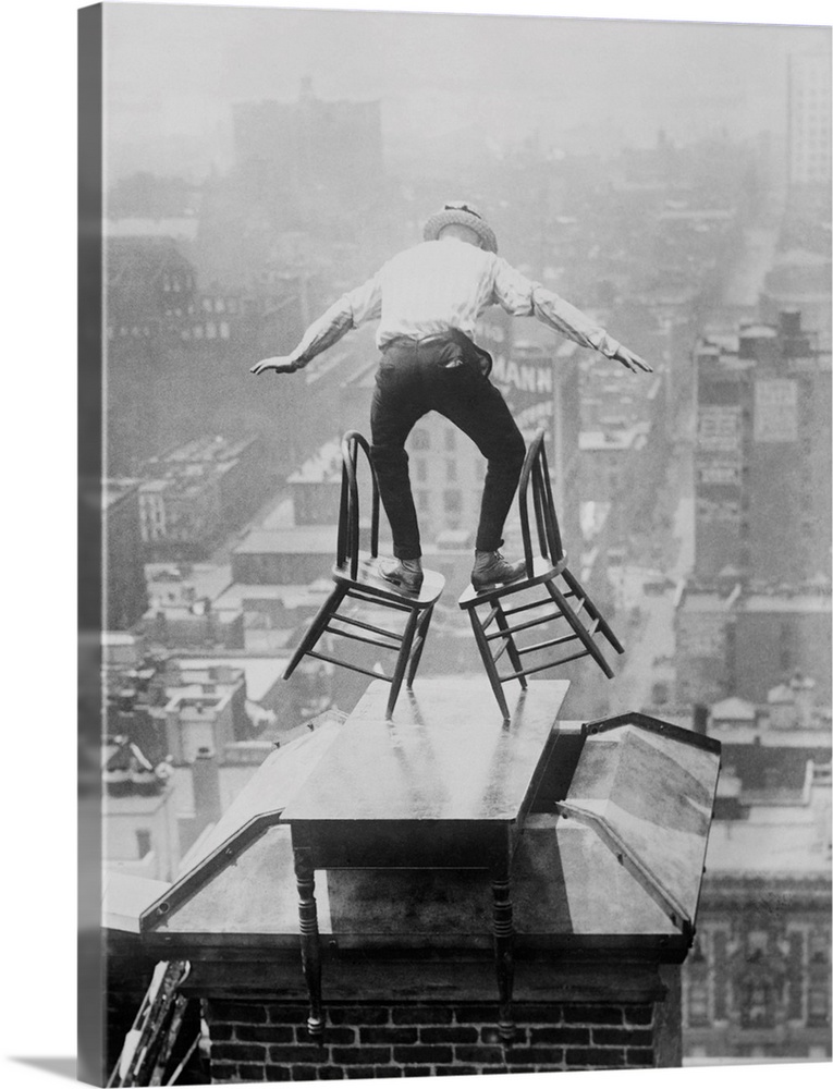 Human Fly' John 'Jammie' Reynolds balances precariously on two tilted chairs. The dare-devil is on the roof edge of a tall...