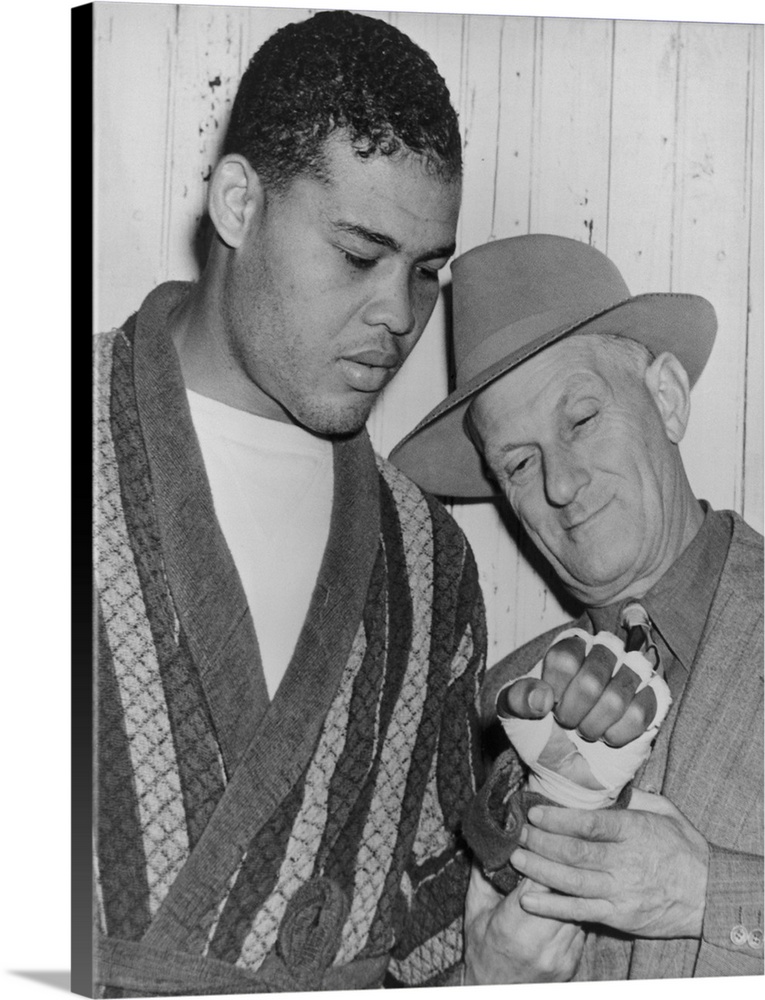 Mike Jacobs inspects Joe Louis' fist before the heavy weight champion would defend his title against Lou Nova on Sept. 29,...