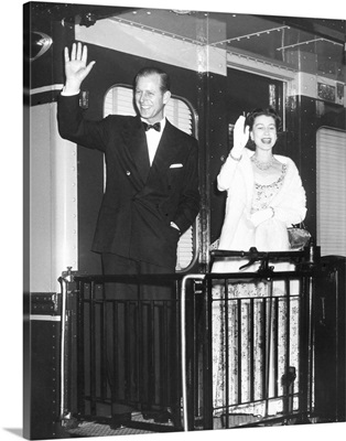 Queen Elizabeth II and Prince Philip wave from the back of a train at Union Station