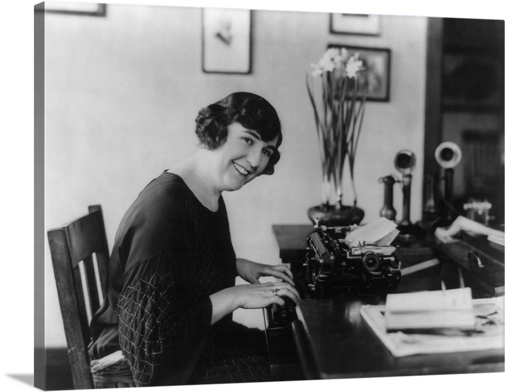 Smiling woman office worker seated at typewriter, in 1923.
