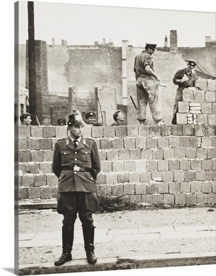 West Berlin policeman stands before the block wall dividing East and West Berlin
