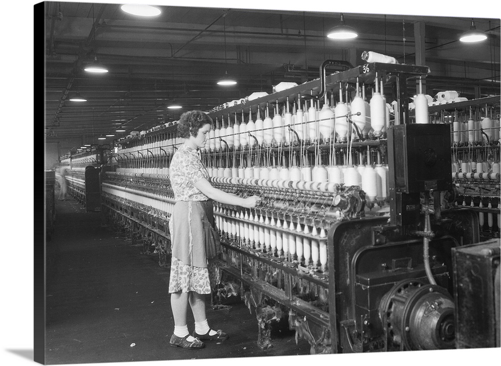 Woman standing at long row of bobbins, at a textile factory. Millville, N.J. 1936. Photo by Lewis Hine.