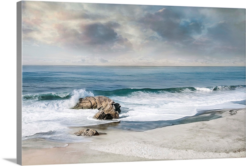 Landscape photograph of waves crashing onto a rock on the sandy shore.