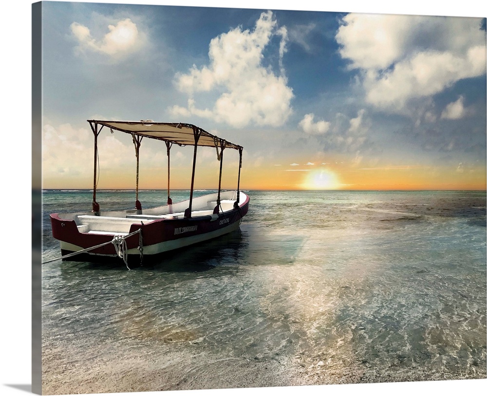In this photo, an anchored boat rests on a bank of the ocean in Costa Maya during a Carribean sunset.