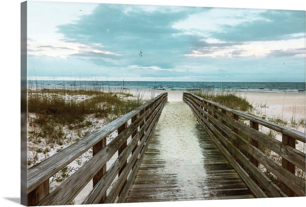 A photo of a boardwalk leading to a sandy unoccupied beach.