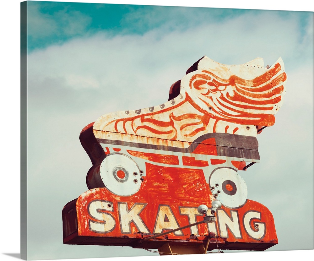 Photograph of a vintage orange roller skating sign on a cloudy sky background.