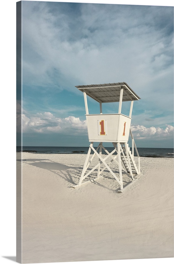 A photo of a lifeguard tower on a cloudy day with an unoccupied beach in the background.