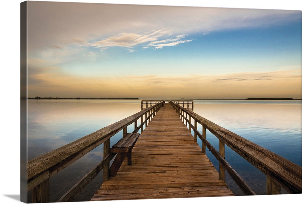 Photograph of a long, wooden pier over the Terra Ceia Bay in Florida with a golden sunset.